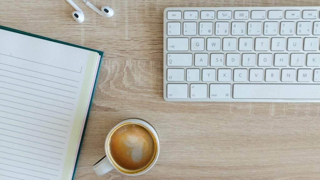 Keyboard, coffee, and notepad